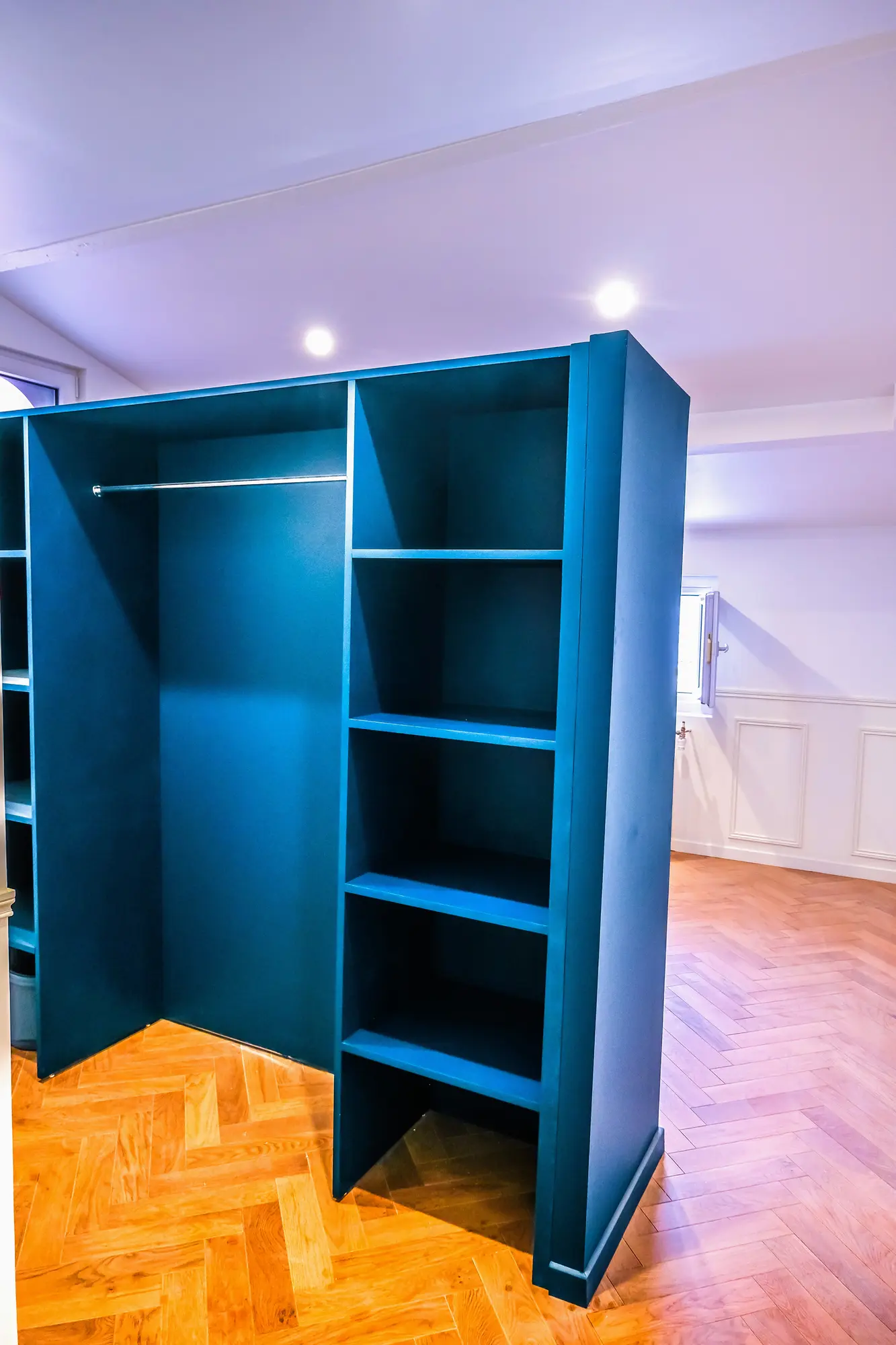 Rangement bleu ouvert avec tablettes et espace de penderie